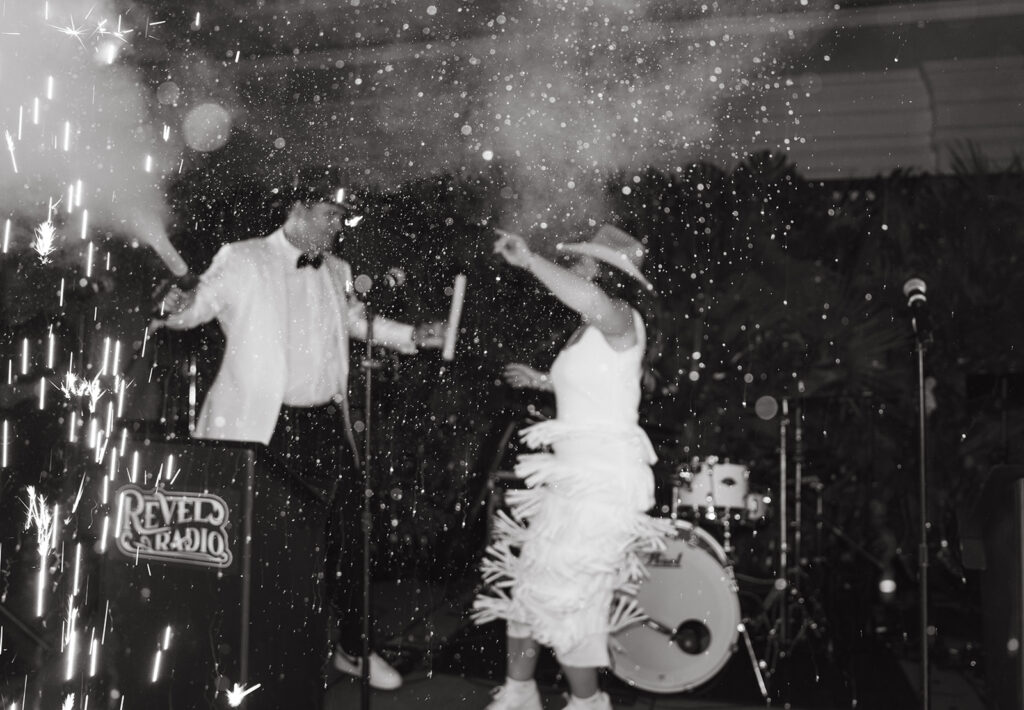 black and white of newlyweds partying, bride in fringe dress