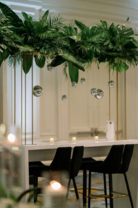 Overhead greenery installation with hanging mirror balls