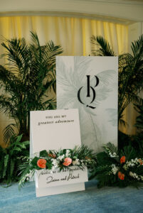 Welcome signage with custom monogram and floral accents